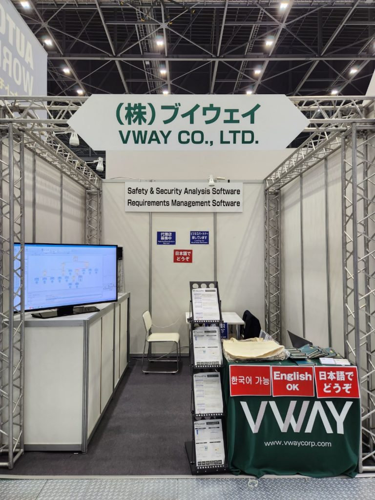 Automotive World NAGOYA 브이웨이 부스 — 「(株)ブイウェイ VWAY CO., LTD.」 간판 아래 Safety & Security Analysis Software 와 Requirements Management Software 안내, 모니터에 STPA 분석 화면, 한국어·English·日本語 응대 가능 표시