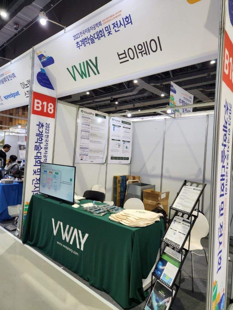 2023 한국자동차공학회 추계학술대회 및 전시회의 브이웨이 부스(B18) — VisualPro 와 Teamer 안내 패널, 모니터에 분석 화면, VWAY 테이블 보와 브로슈어 거치대