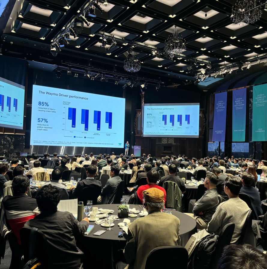 2024 Korean SPICE Network International Conference 강연장 전경 — 자율주행 Waymo Driver 성능(부상 사고율 85% 감소, 경찰 신고 사고율 57% 감소) 발표 슬라이드와 만석의 청중