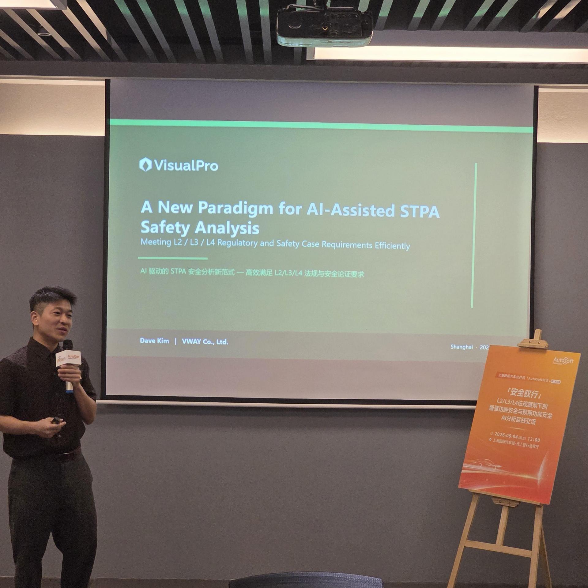 「AutoSoft 대화」 제23회 발표 장면 — VWAY 발표자가 마이크를 들고 「A New Paradigm for AI-Assisted STPA Safety Analysis」 첫 슬라이드 앞에 서 있다