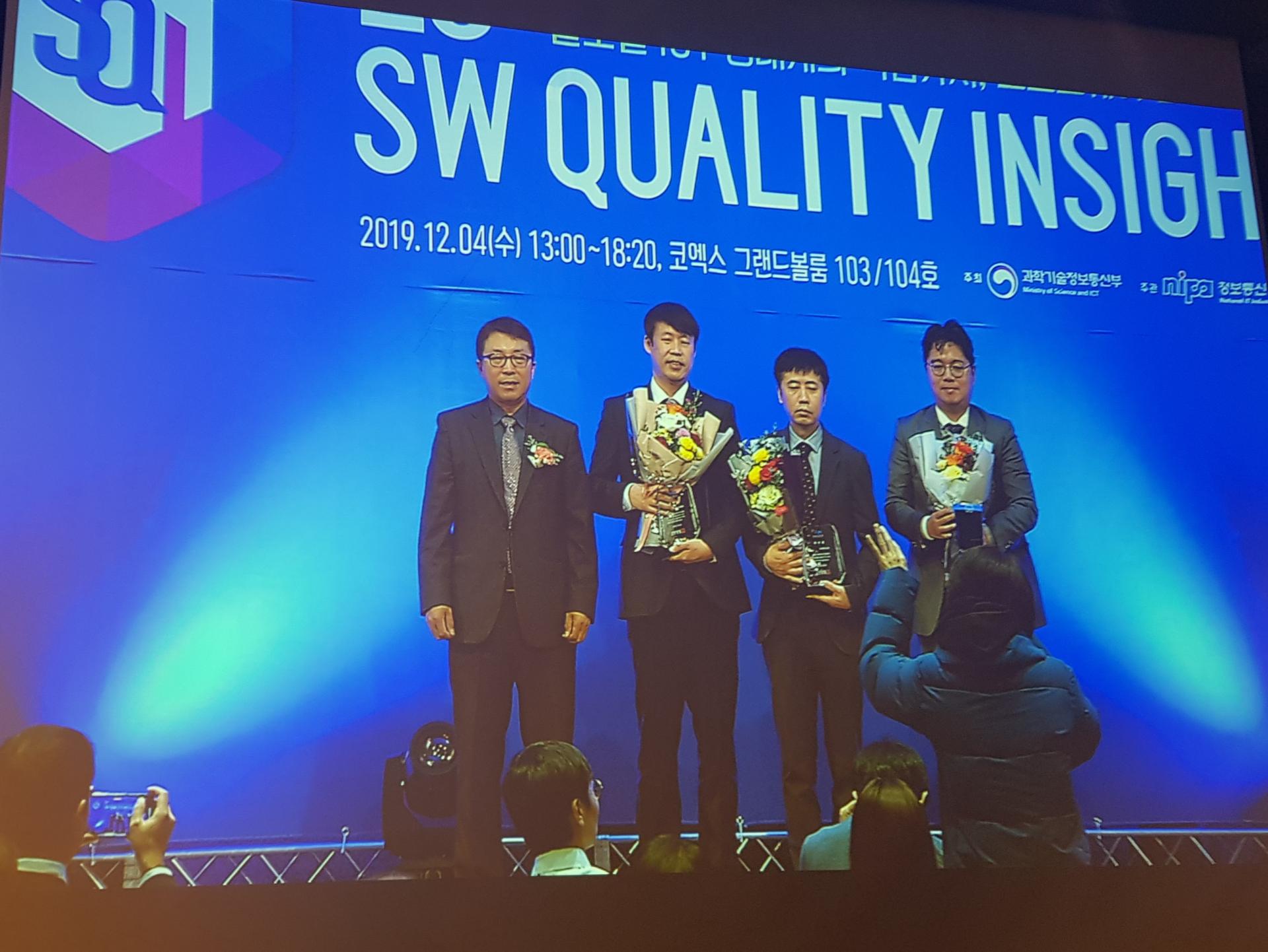 제26회 SW Quality Insight 시상식 무대에서 꽃다발을 든 수상자들과 시상자 단체 사진