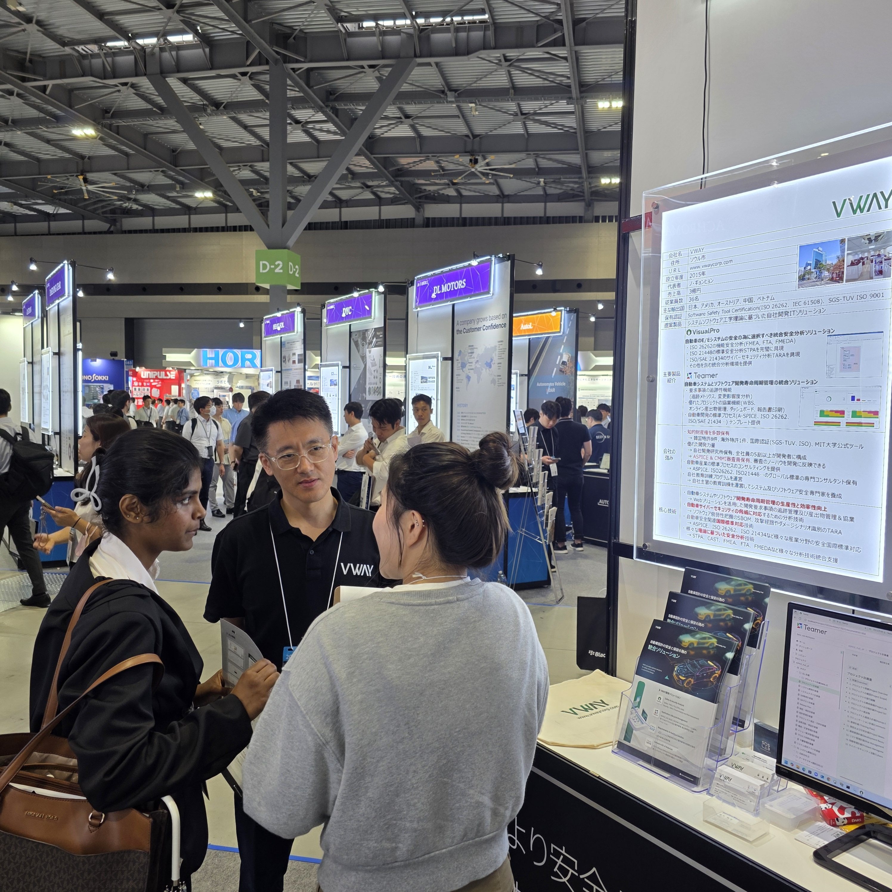 Automotive Engineering Exposition 2025 Nagoya 브이웨이 부스(D-2 구역)에서 해외 방문객들과 상담하는 모습