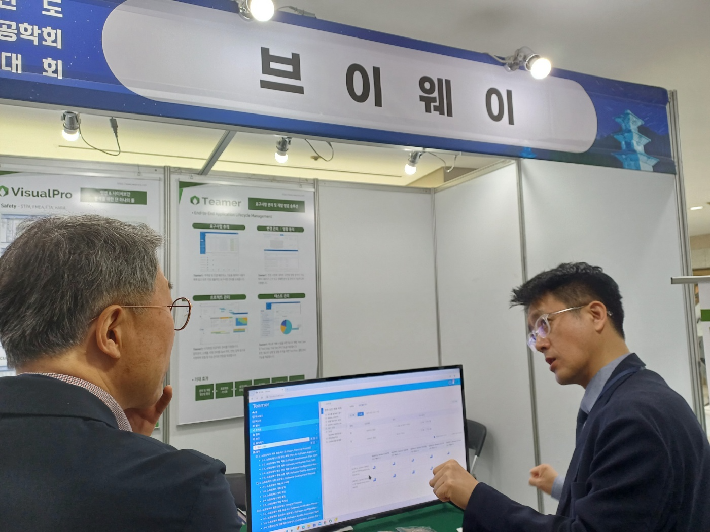 항공우주시스템공학회 춘계학술대회 브이웨이 부스에서 Teamer 의 소프트웨어 개발 프로세스 관리 화면을 설명하는 모습