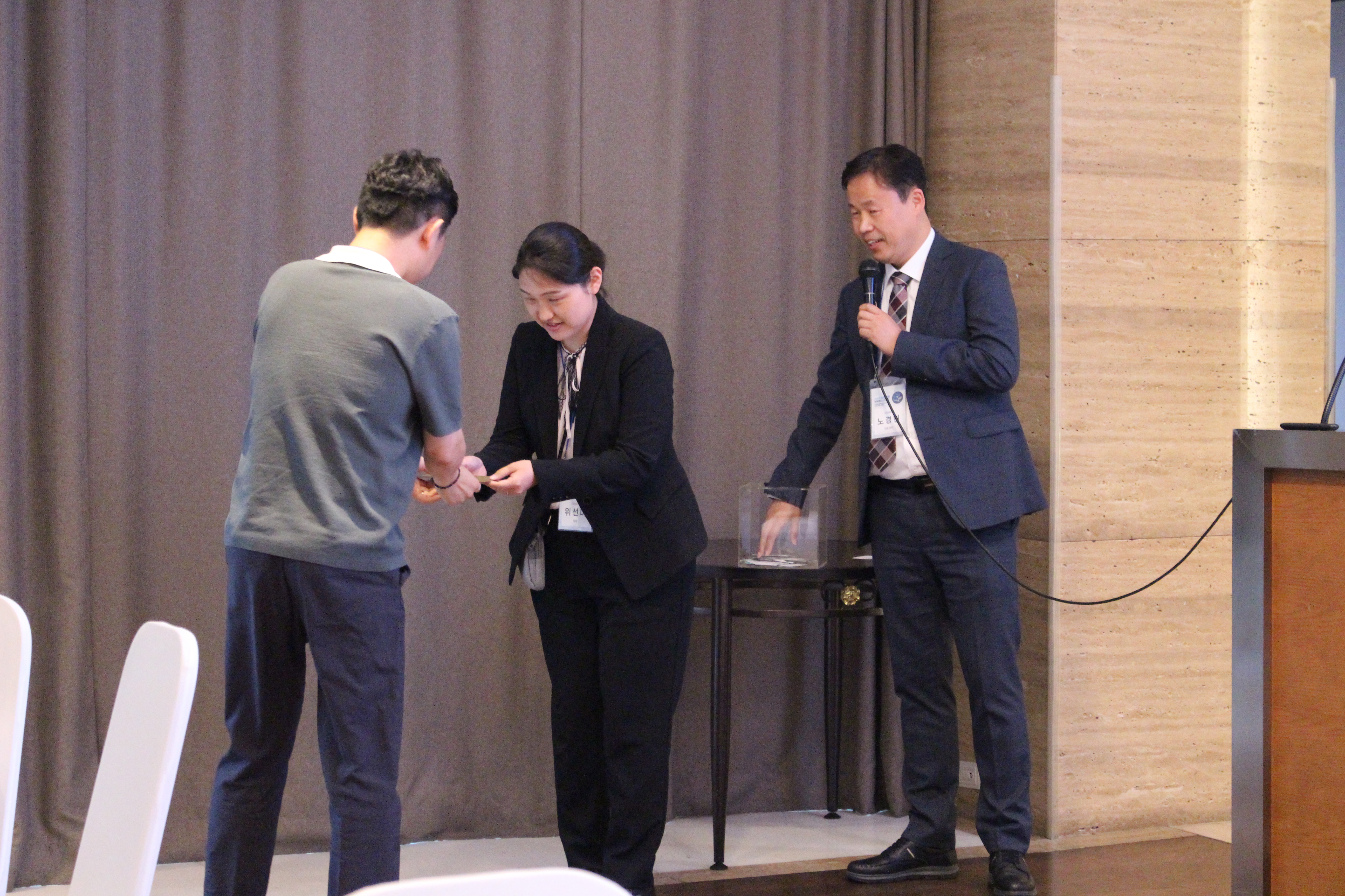 스마트 의료 안전 컨퍼런스 2025 경품 추첨 — 무대에서 추첨함에서 번호를 뽑는 모습