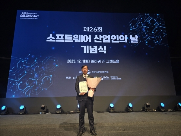 제26회 소프트웨어 산업인의 날 기념식(2025.12.1 엘타워 그랜드홀) 무대에서 노경현 대표가 표창장과 꽃다발을 들고 선 모습