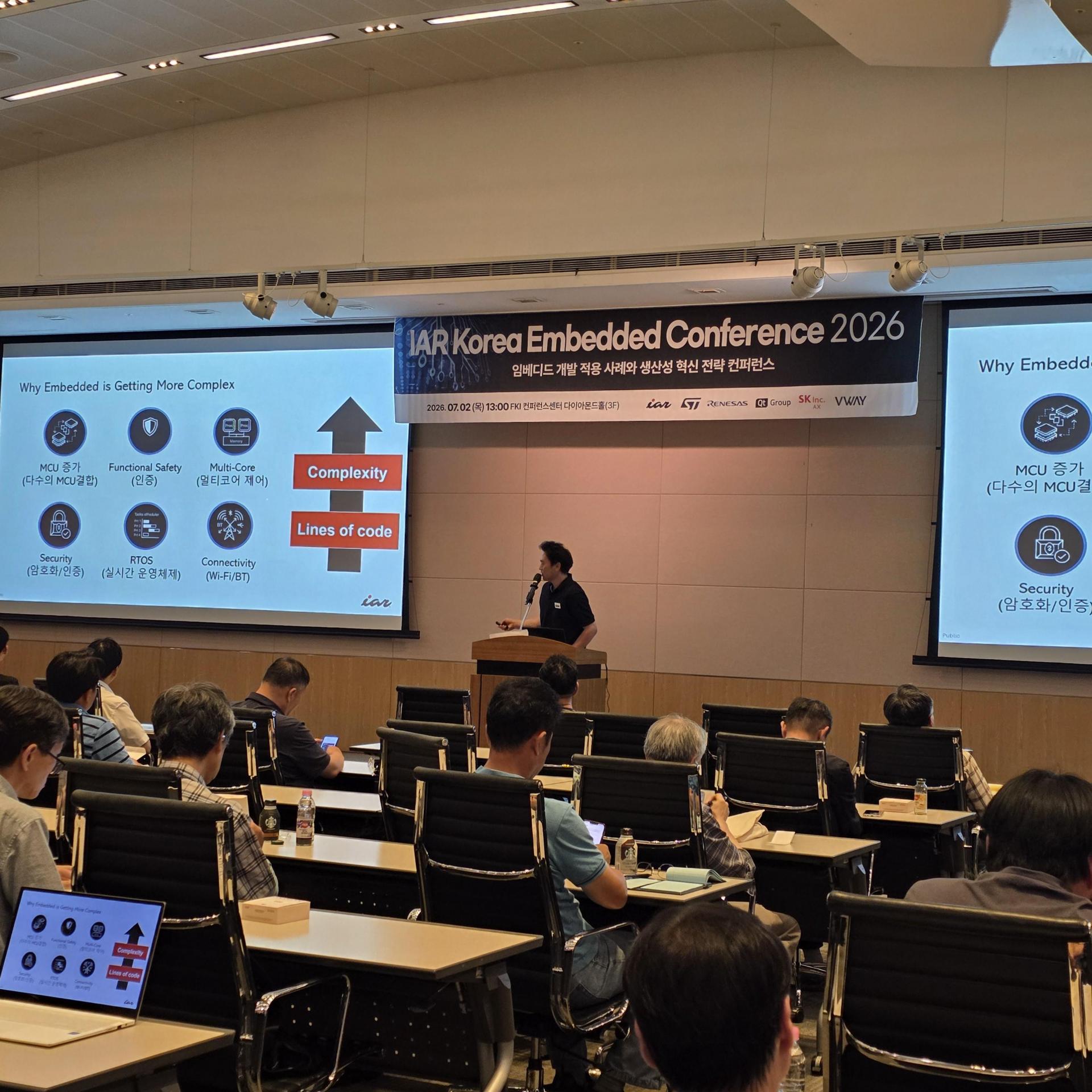 IAR Korea Embedded Conference 2026 강연장 — 세 화면에 발표 자료가 띄워진 무대와 청중