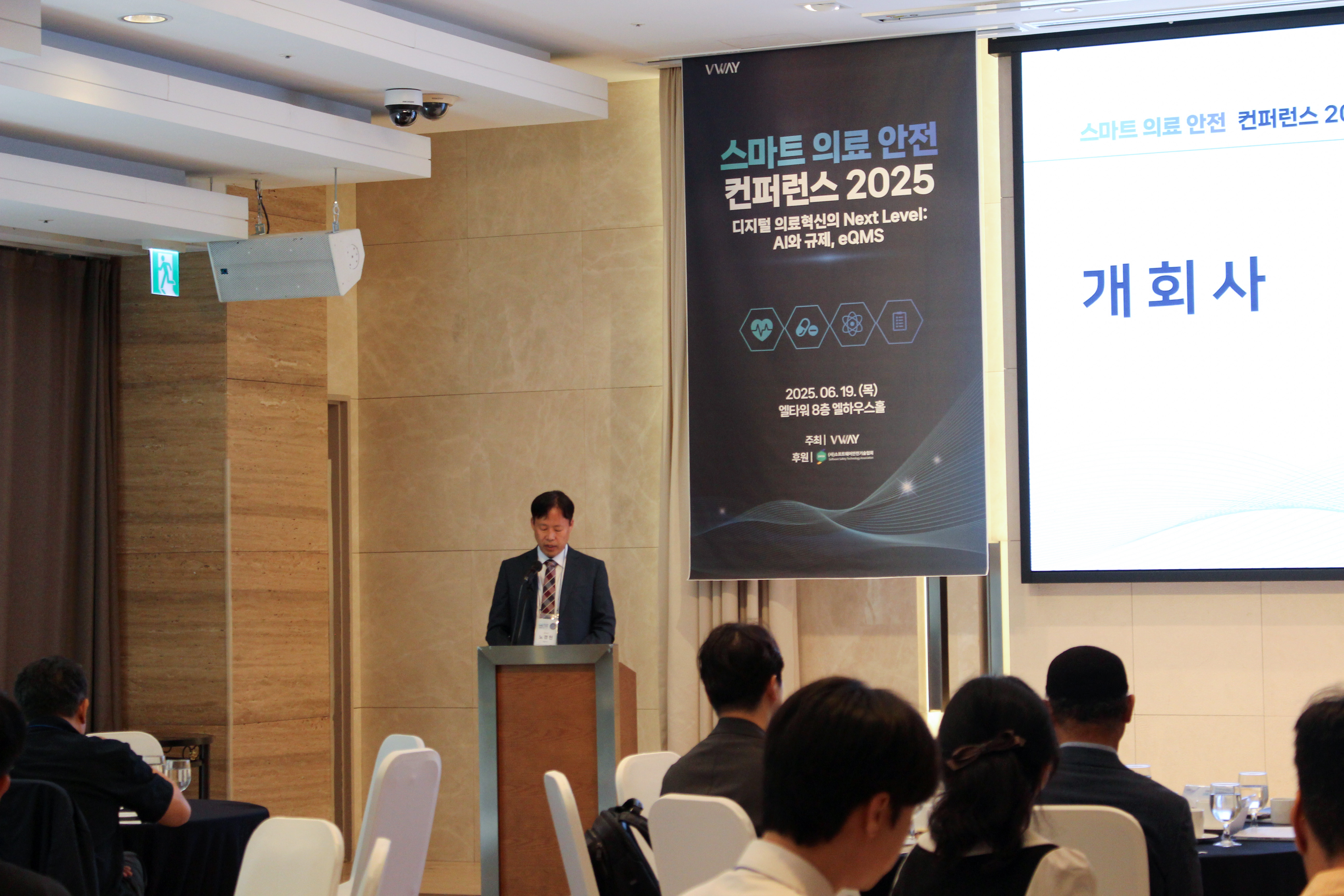 스마트 의료 안전 컨퍼런스 2025 개회사 — 연단에서 인사말을 하는 노경현 대표와 '개회사' 화면